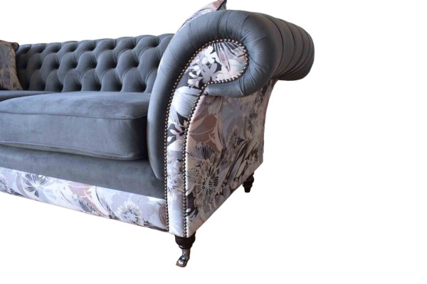 Ein auffälliges Dreisitzer-Sofa im Chesterfield-Design mit zarter grauer Blumendekoration