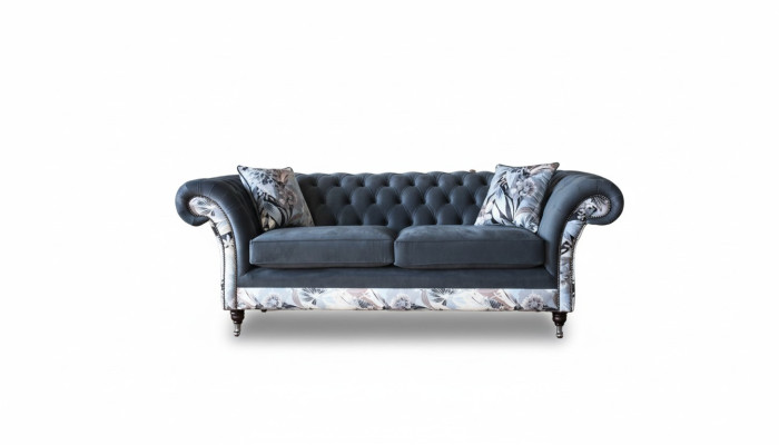 Ein auffälliges Dreisitzer-Sofa im Chesterfield-Design mit zarter grauer Blumendekoration